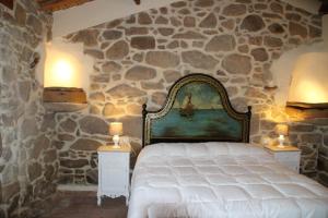 ein Schlafzimmer mit einem Bett in einer Steinmauer in der Unterkunft Stazzo Gallurese La Cugara in Aglientu