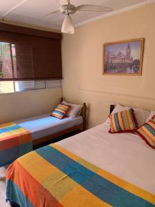 a bedroom with two beds and a ceiling fan at Hotel Pousada Ibituruna in Sao Paulo