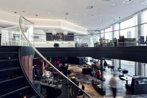 a lobby of a building with a staircase and people at Mainport Design Hotel in Rotterdam