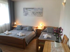 a bedroom with two beds and a table at Dom Natura in Grzybowo