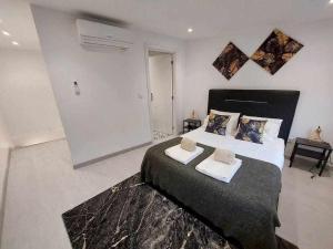 una camera da letto con un letto grande con due asciugamani sopra di Alto da lapa Luxury house free 1 parking place a Porto