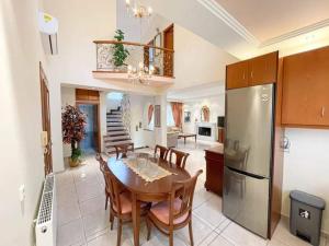 a kitchen and dining room with a table and a refrigerator at Endless Blue Seaside in Paleo Tsifliki