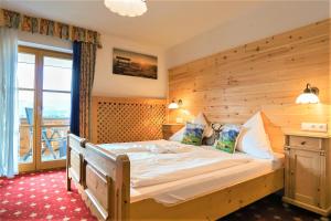 a bedroom with a large bed with a wooden wall at Ferienhaus und Landhaus Berger in Füssen