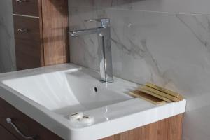 a white bathroom sink with a faucet and wood at jawharat alshlal Establishment in Hafr Al Baten +40 photos