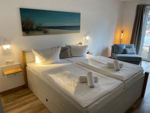1 cama blanca grande en una habitación con silla en Hotel meerblau, en Ostseebad Sellin