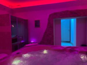 um quarto roxo com uma banheira e um espelho em Aurora em Gubbio