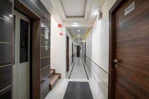 a corridor of a hallway with a door and stairs at Hotel Ashish in Ahmedabad