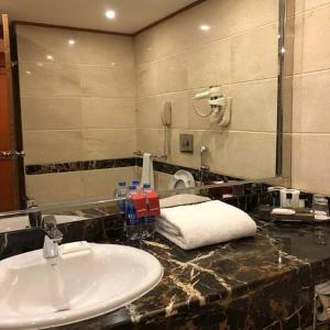 a bathroom with a sink and a mirror at Hotel Grand Lahore in Lahore