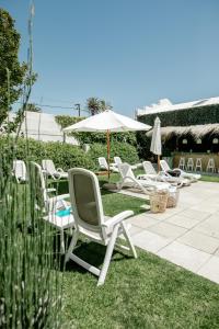 a group of lawn chairs and an umbrella at Atlántico Boutique Hotel in Punta del Este