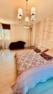 a large bed in a bedroom with a chandelier at Domaine Les Cigales in Mouans-Sartoux