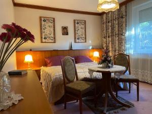 a bedroom with a bed and a table and chairs at Suburb Hostel in Purkersdorf