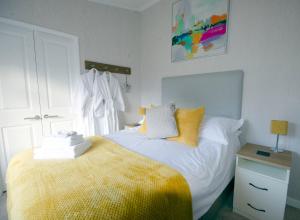 a bedroom with a bed with a yellow blanket at Hollicarrs - Long Lane Lodge in York