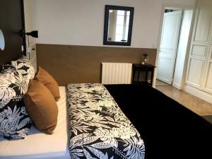 1 dormitorio con 1 cama con edredón blanco y negro en Raconte-Moi Une Histoire, en Bayeux