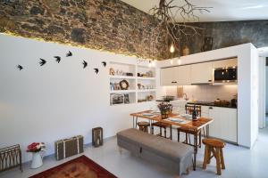 a kitchen and dining room with a table and birds on the wall at Sparrow Sintra Nest in Sintra