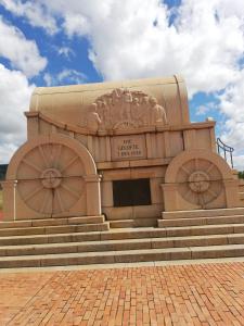 a building with a statue on top of some stairs at Blood River Museum Guesthouse in Dundee