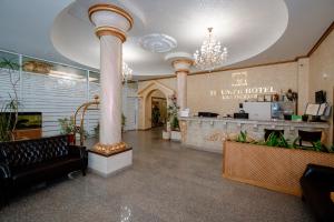 a lobby of a hotel with columns and a counter at Triumph Hotel in Krasnodar