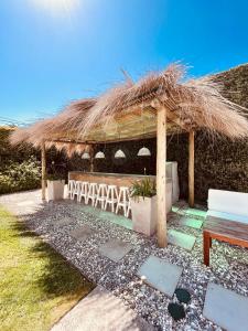 a straw hut with a bench and a table at Atlántico Boutique Hotel in Punta del Este