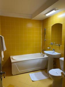 La salle de bains est pourvue d'une baignoire, de toilettes et d'un lavabo. dans l'établissement Hotel Miraj - Restaurant & Sauna & Biliard, à Poiana Brasov