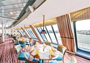 uma sala de jantar num cruzeiro com mesas e cadeiras em Viking Line ferry Gabriella - Cruise Helsinki-Stockholm-Helsinki em Helsínquia