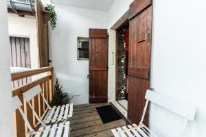 a porch with two chairs and a wooden door at Cozy apartment near the city center in Megève