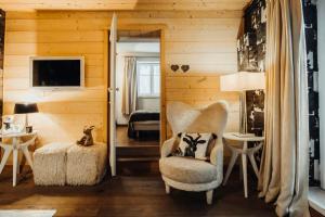 a living room with a chair and a bedroom at Cozy apartment near the city center in Megève