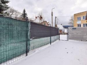 um campo de ténis coberto de neve com uma cerca em POD BZEM em Szczytna