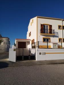 a white house with a gate and a fence at PoolSeaView Spacious House in Atouguia da Baleia