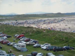a bunch of cars parked in a parking lot next to a beach at Sun Apartments in Enniscrone