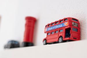 a red double decker bus toy on a shelf at Appartements London/New York in Forheim