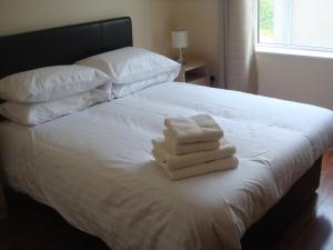 a bedroom with a bed with two towels on it at Sun Apartments in Enniscrone