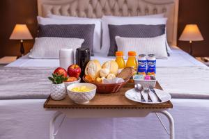a tray of food on top of a bed at Hotel Gambrinus in Poços de Caldas