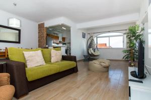 a living room with a couch and a television at Ocean View Apartment - Pool and Sea View & Albufeira Center in Albufeira