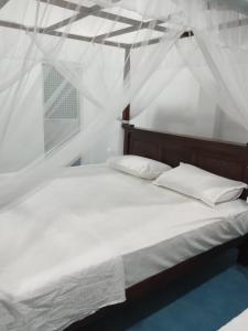 a white bed with two pillows in a room at NOVA Guest in Mirissa