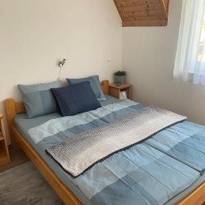 a large bed with blue sheets in a bedroom at Chestnut Hill- Zalakaros in Zalakaros