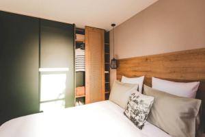 sypialnia z łóżkiem z białymi poduszkami w obiekcie Camping Le Bois Verdon w mieście Saint-Jean-de-Monts