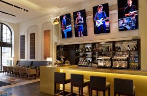 a bar in a restaurant with several pictures on the wall at Reichshof Hotel Hamburg in Hamburg