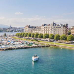 un bateau dans l'eau devant une ville dans l'établissement The Woodward - an Oetker Collection Hotel, à Genève