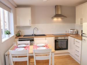 a kitchen with a table with chairs and a sink at The Little Dingle in Church Stretton