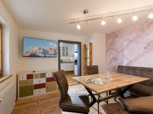 uma sala de jantar com uma mesa e uma televisão na parede em abacus-Ferienwohnung em Hopfgarten im Brixental