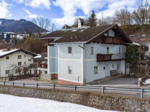 a white house with a roof in the snow at abacus-Ferienwohnung in Hopfgarten im Brixental