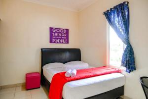 a bedroom with a bed with a red blanket and a window at Pondok Malabar Mitra RedDoorz in Jakarta
