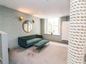 ein Wartezimmer mit einer grünen Couch und einem Spiegel in der Unterkunft 36 The Salcombe in Salcombe