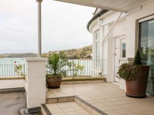 ein Balkon mit Topfpflanzen an einem weißen Haus in der Unterkunft 36 The Salcombe in Salcombe