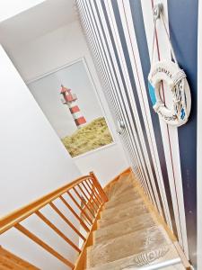 klatka schodowa w domu z latarnią morską na ścianie w obiekcie Promenada by Baltic Home w Świnoujściu