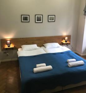 Hotel Loft في تبليسي: غرفة نوم بسرير ازرق عليها منشفتين