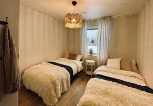 2 Betten in einem Zimmer mit Kronleuchter in der Unterkunft Guestly Homes - Spacious 3BR Apartment with 6 Beds in Boden