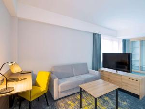 a living room with a couch and a tv at ibis styles Grudziadz in Grudziądz