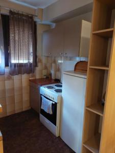 a small kitchen with a stove and a refrigerator at Hills Apartment in Niš
