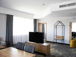 Televízia a/alebo spoločenská miestnosť v ubytovaní ibis styles Grudziadz