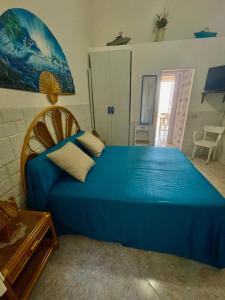 a bedroom with a blue bed in a room at Il Muretto in Marettimo